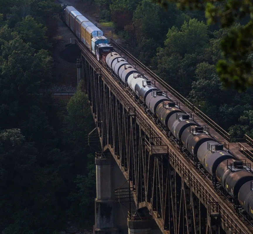A tank train crossing a steel truss bridge