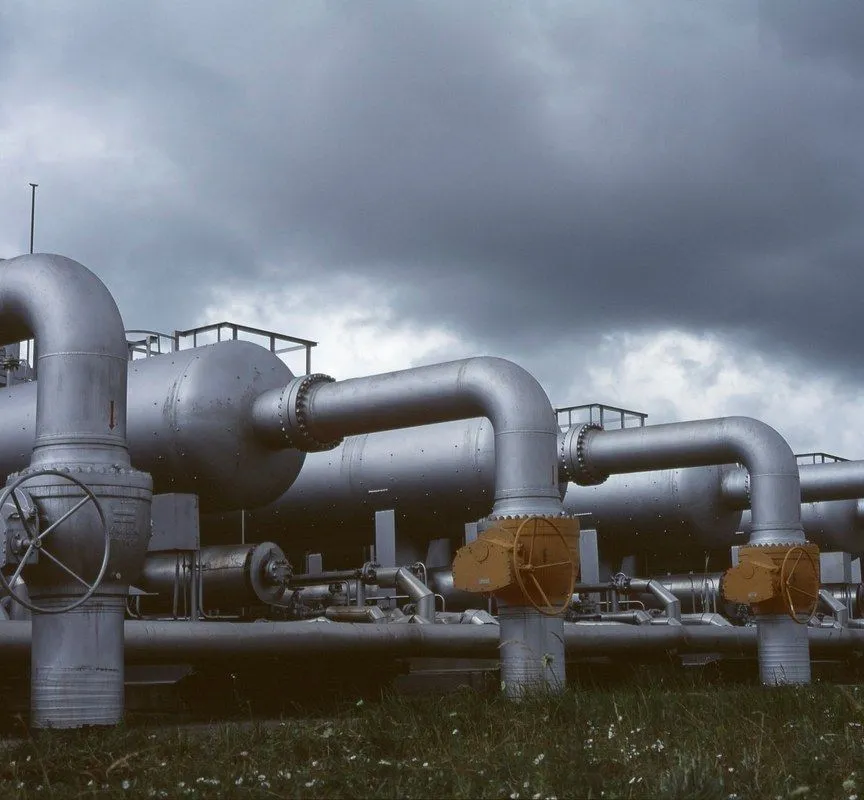 A pipeline manifold under a storm sky